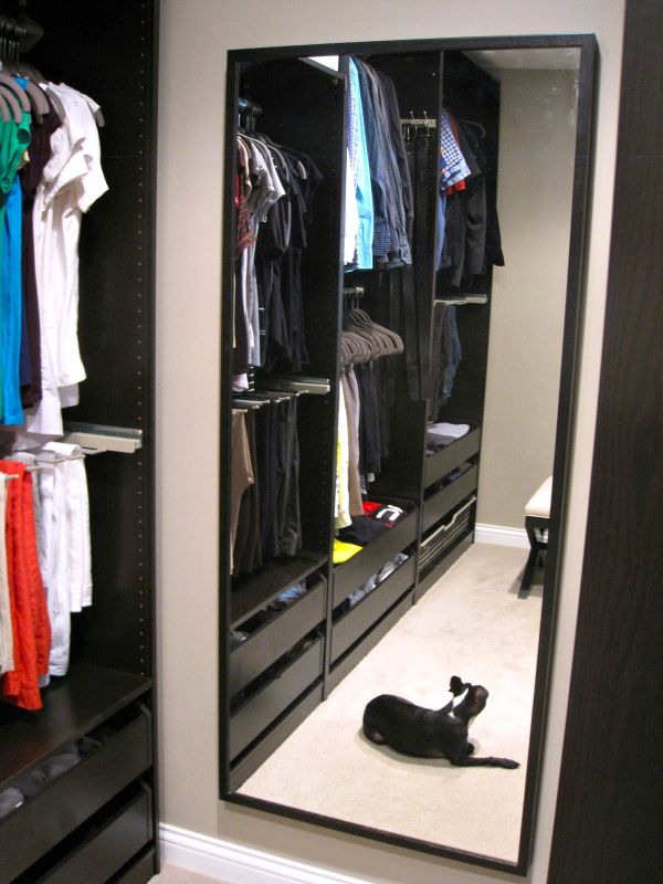 a walk-in closet that uses the Ikea PAX wardrobe closet system in black 