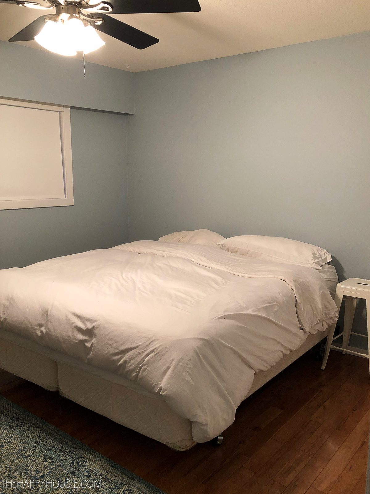 A bed in the middle of a bedroom with no decor.