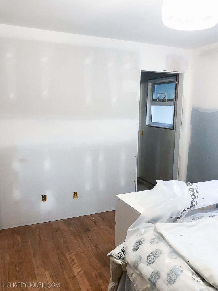 Walls in a bedroom being primed for paint.