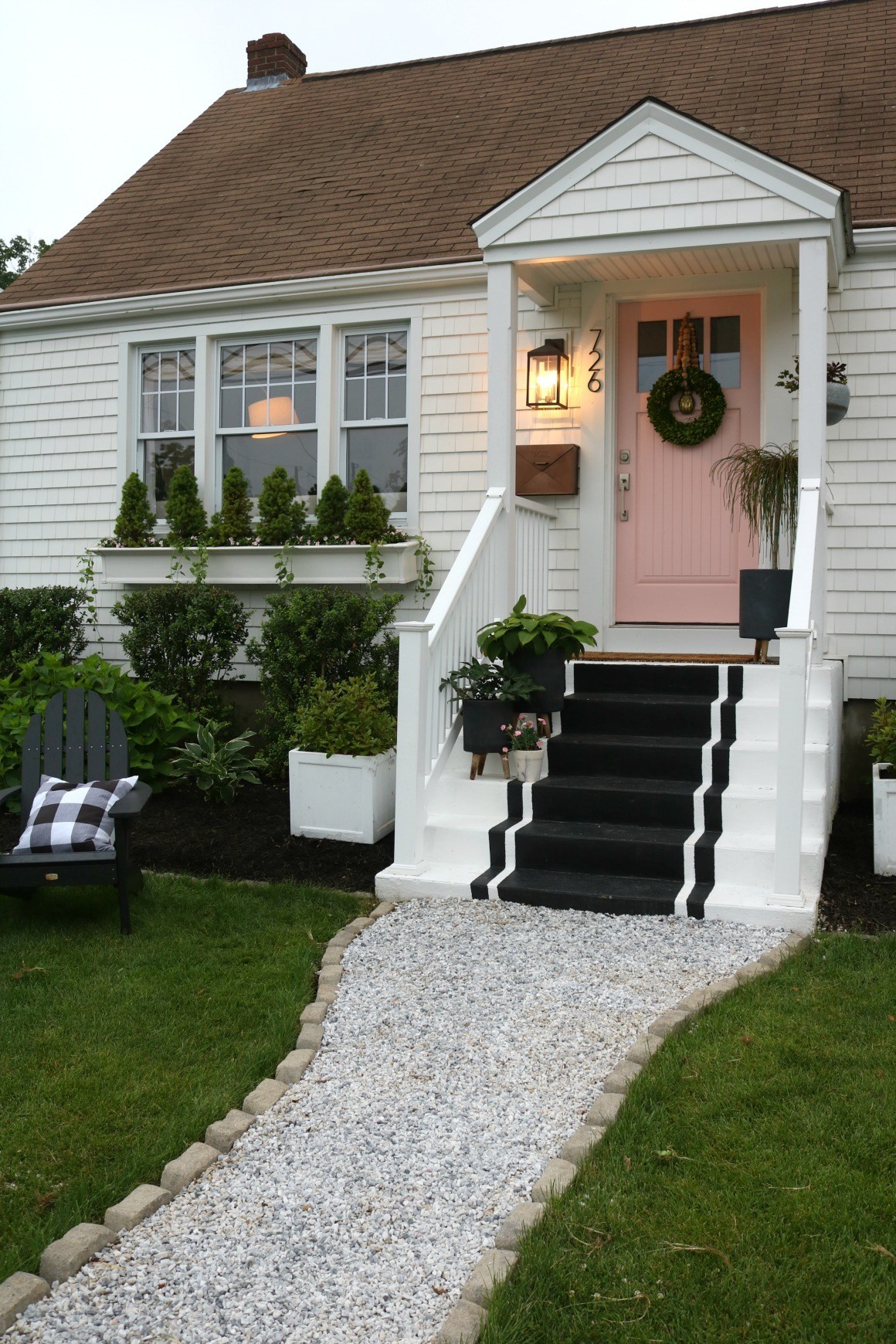 A peachy pink door adds interest to this white home.