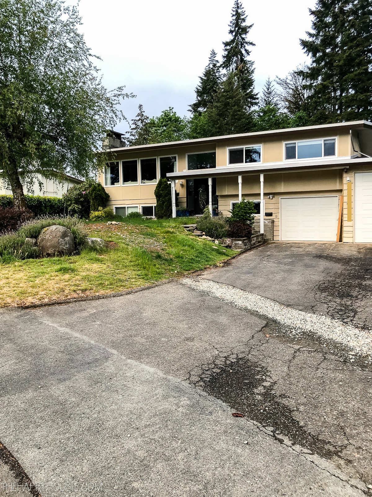 A split level home with a damaged driveway.
