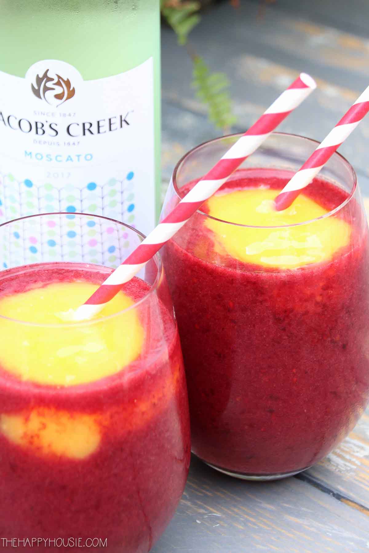 Two clear glasses filled with blackberry mango slushie.