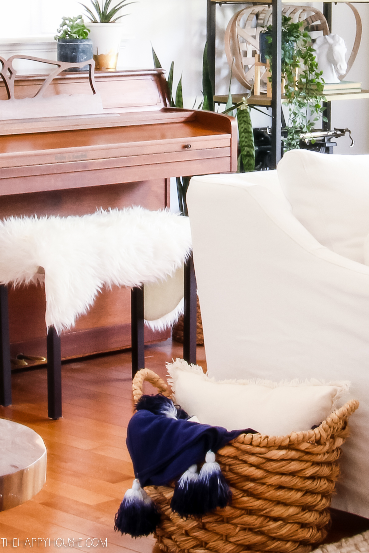 A white faux fur throw is on the piano bench.