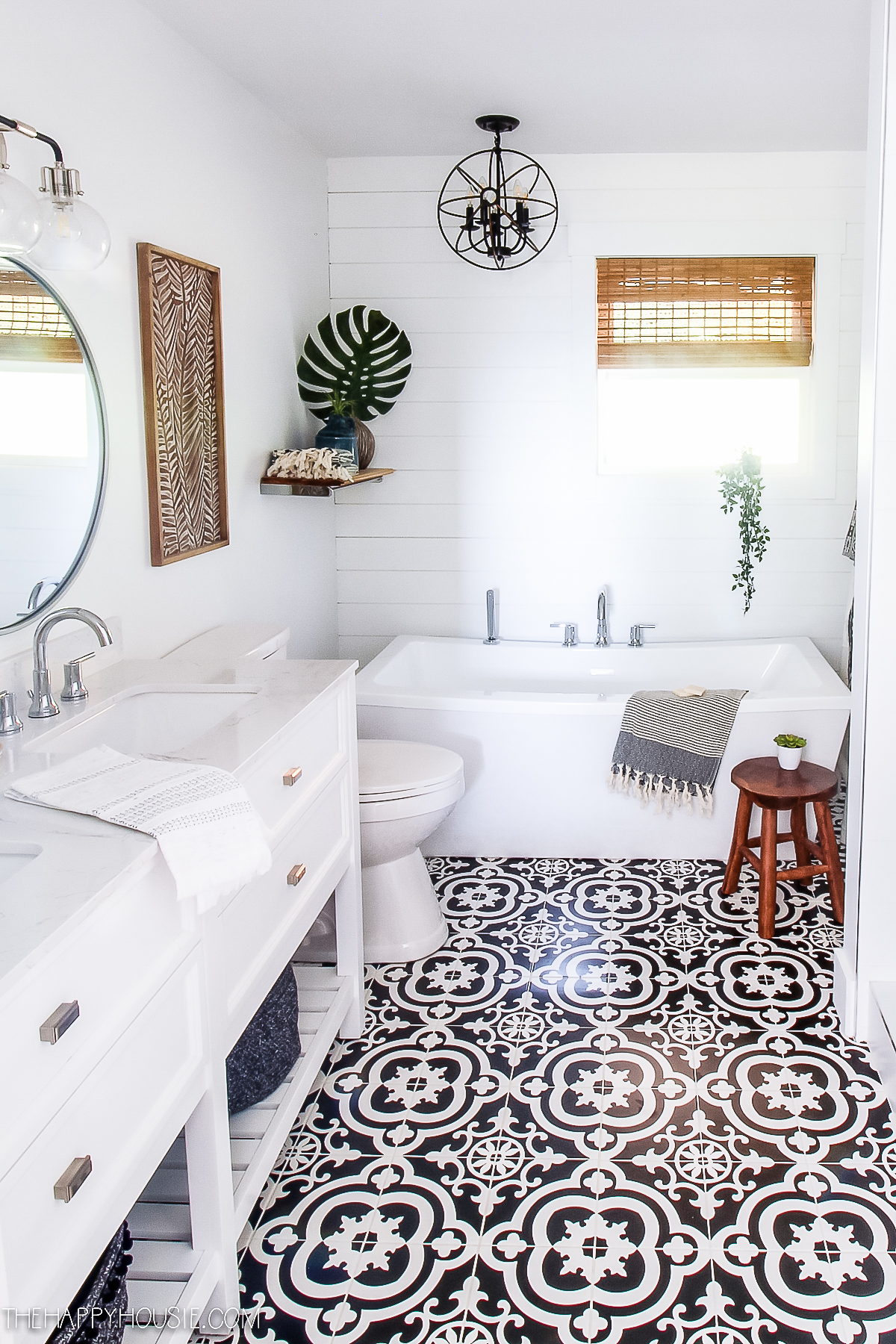 The same bathroom with a black and white floor and a white vanity.