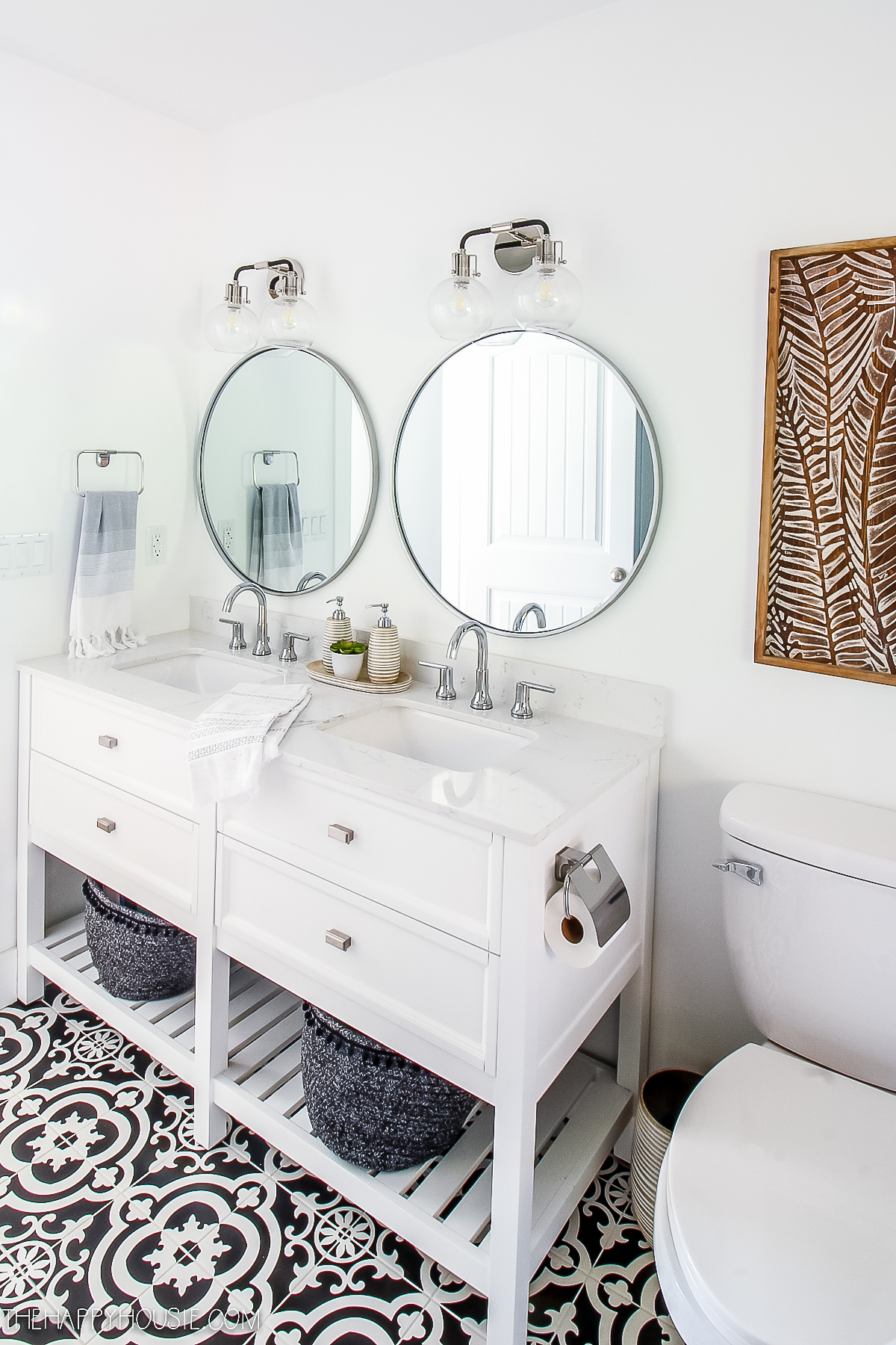 A white vanity with updated faucets.