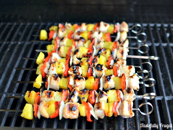 Sweet and sour chicken kabobs on skewers on the grill.