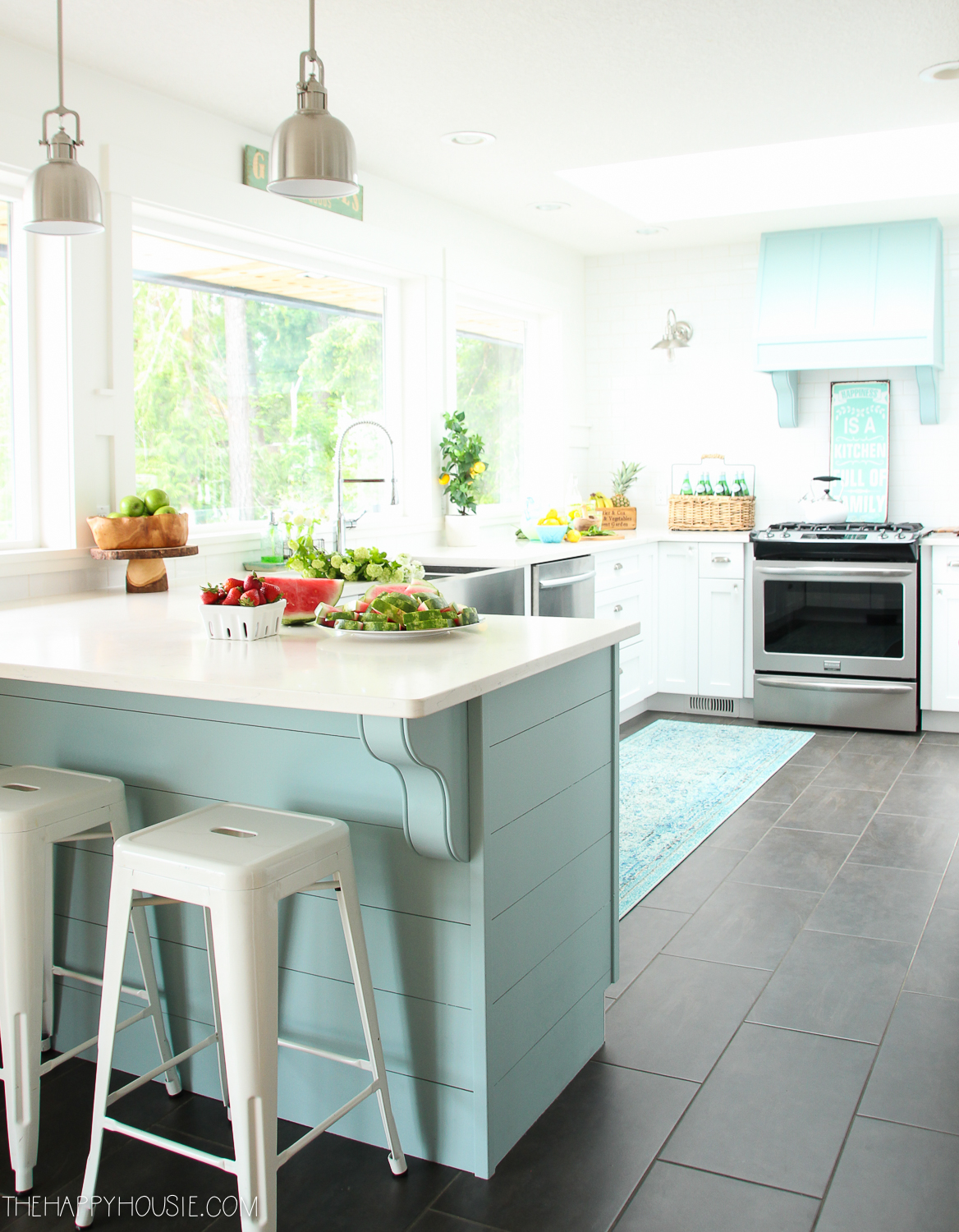 A white and blue kitchen with stools at a small island.