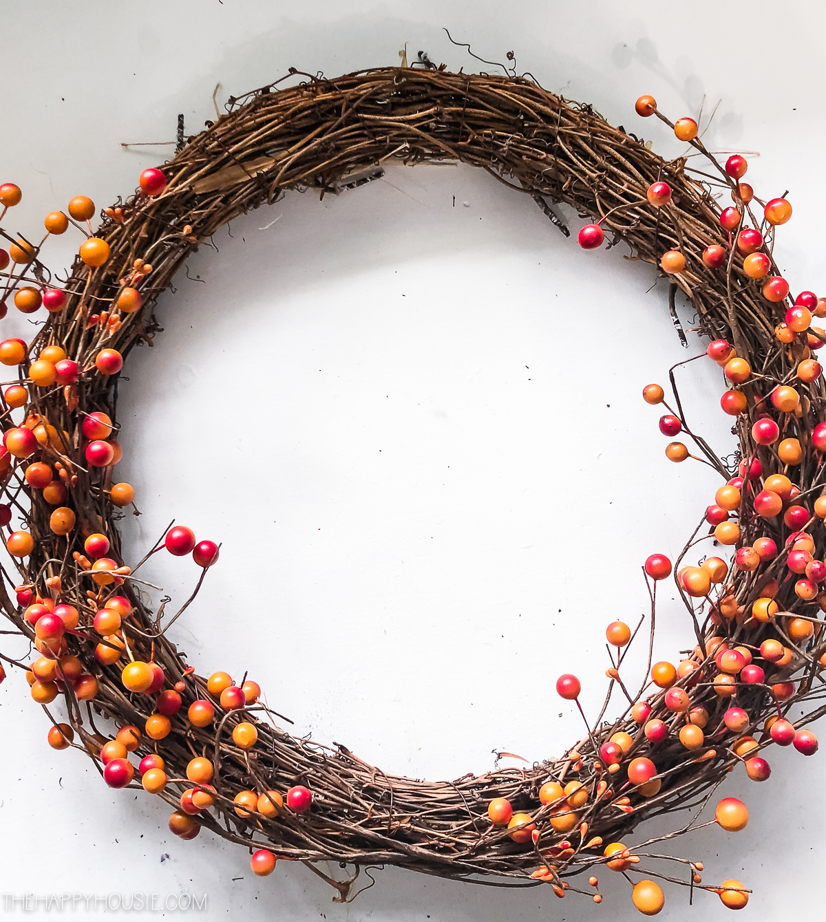 The berry branches winding up both sides of the wreath.