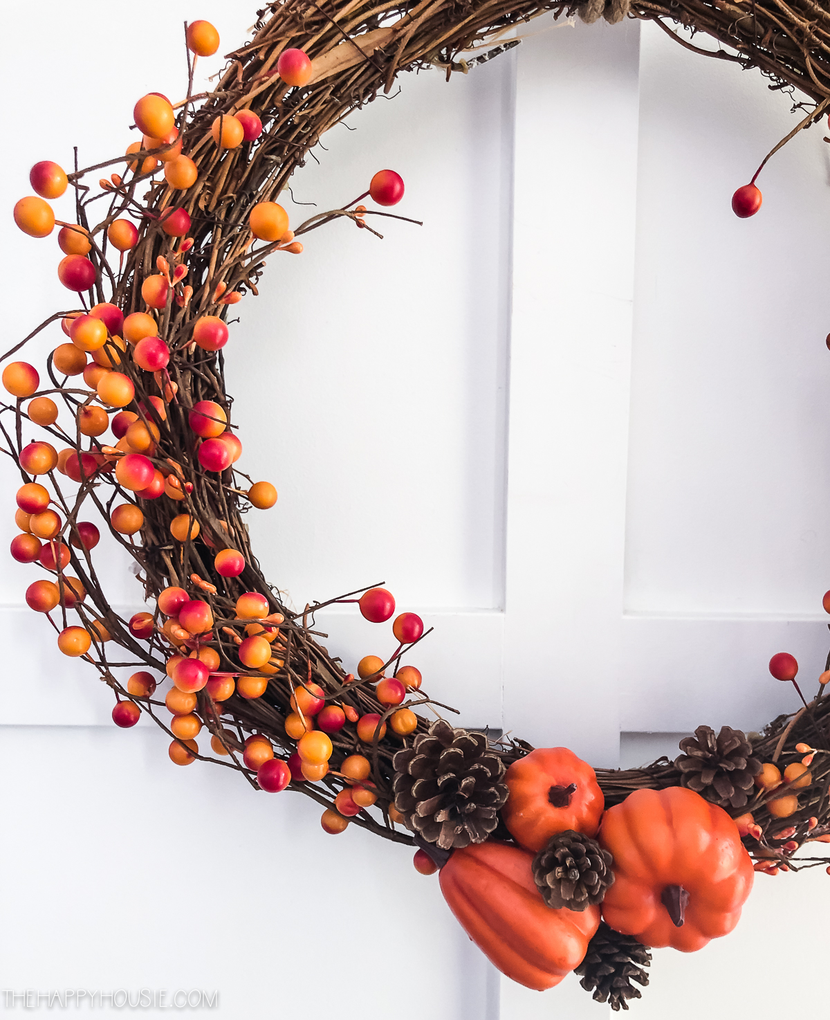 A wreath with orange and red berries on it.
