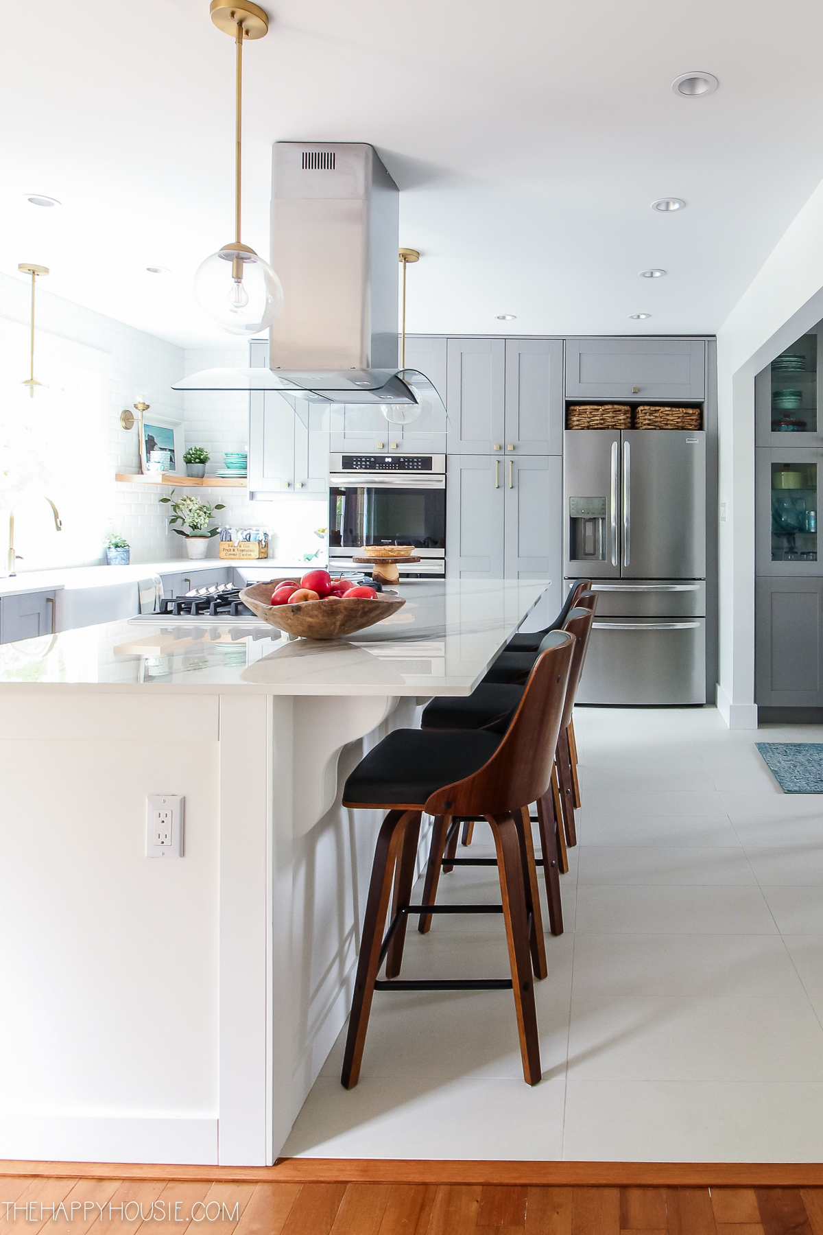 A white kitchen island with a light above it is in the newly renovated kitchen.