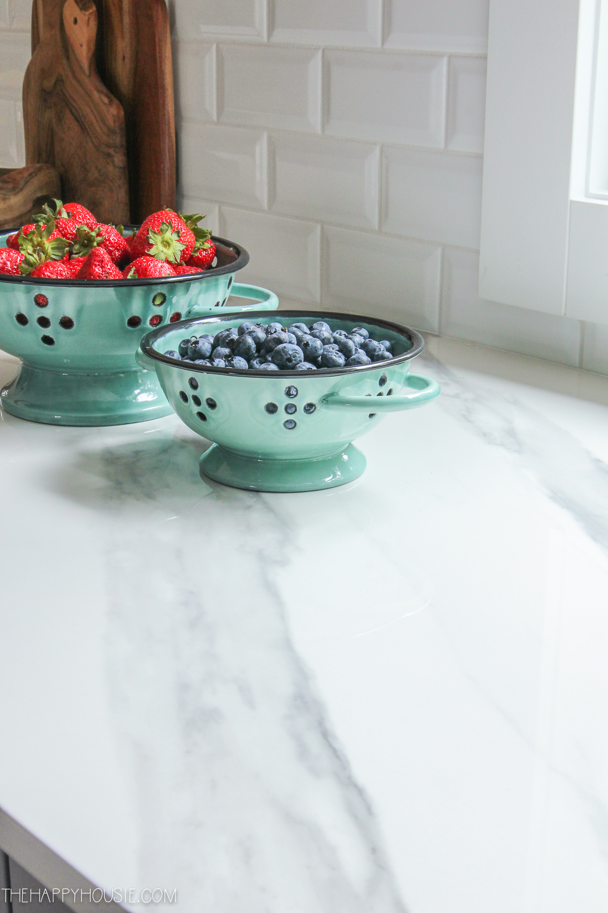Turquoise bowls in the kitchen filled with fruit.