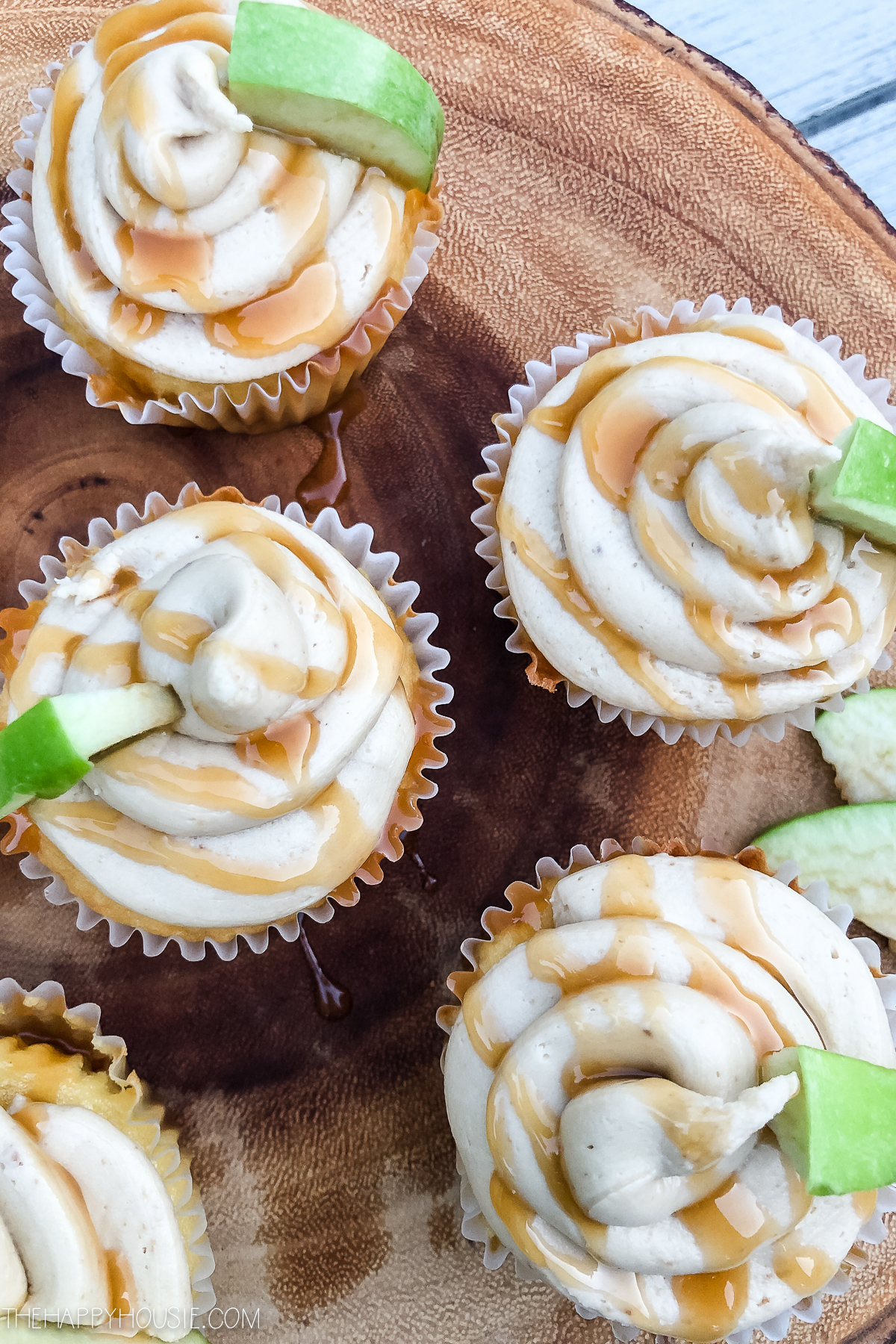 The caramel apple cupcakes on a wooden serving tray.