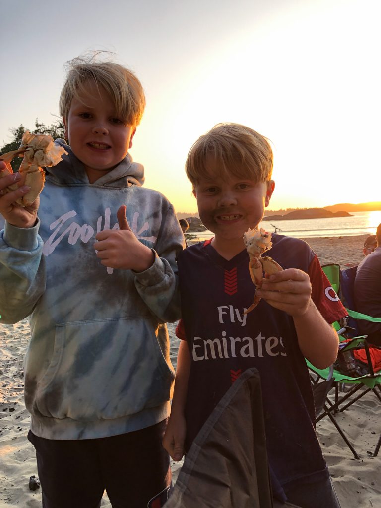 Two boys holding crab.