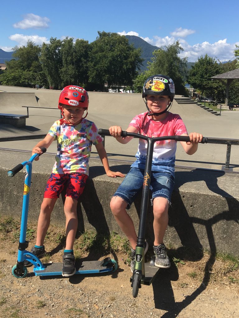 Two boys and their scooters.
