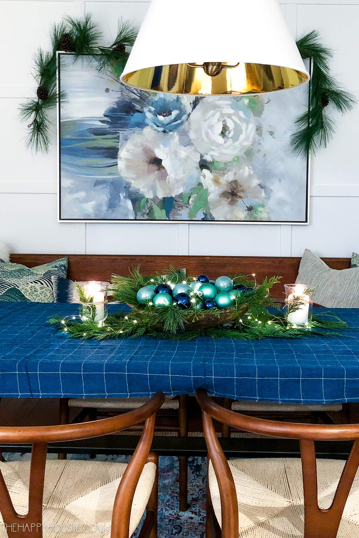 There is a Christmas ornament centrepiece with blue and green ornaments in the middle of the table.