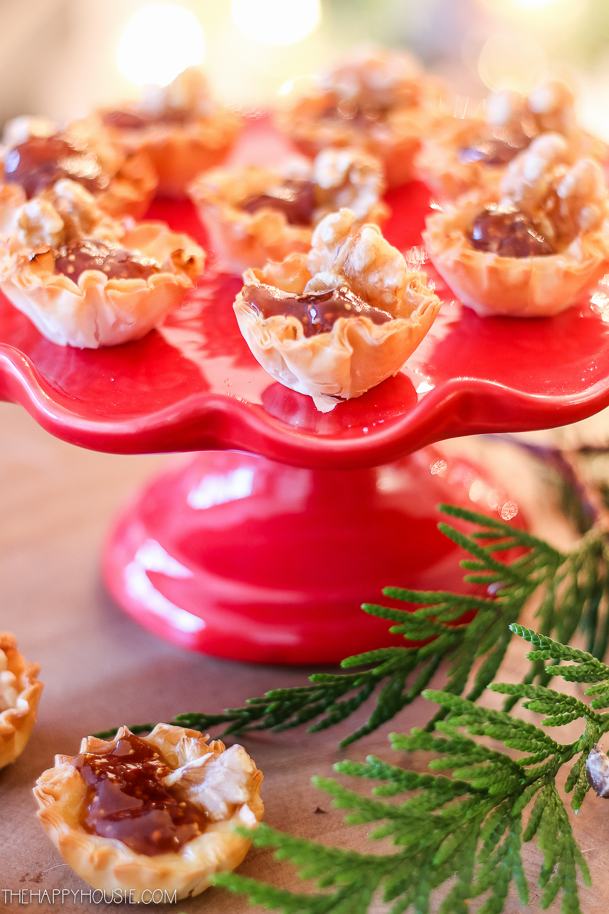 The brie phyllo cups on a red cake pedestal.