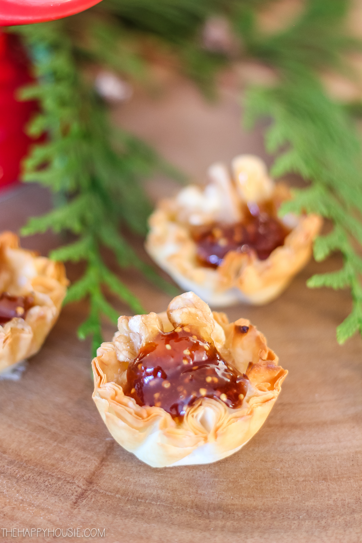 Phyllo cups with baked brie on a charcuterie board.