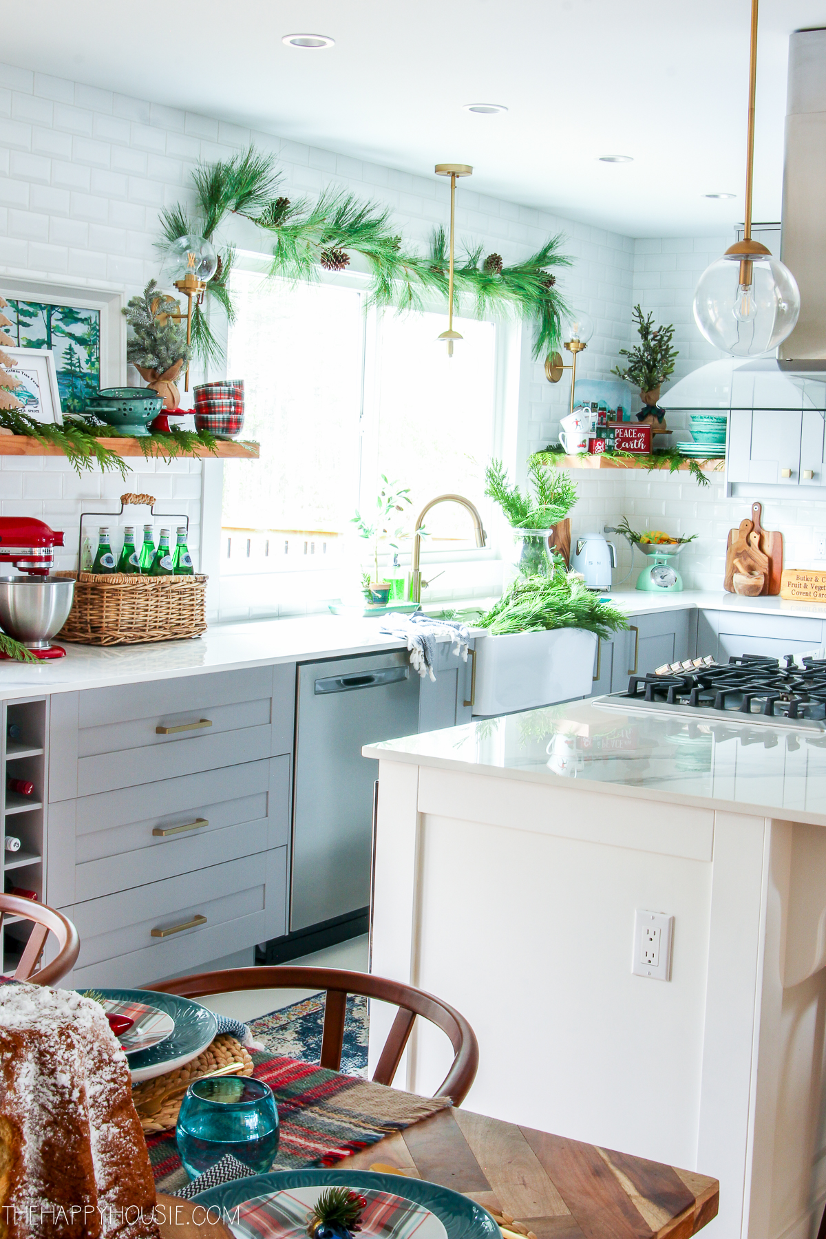 The white and bright kitchen with holiday decorations in it.