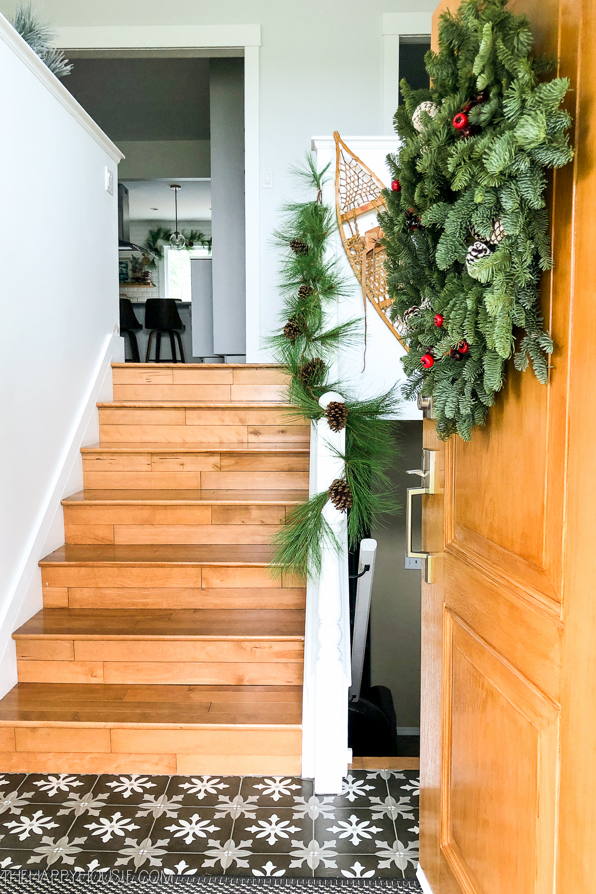 A green garland leading to the top of the stairs on the stairwell.