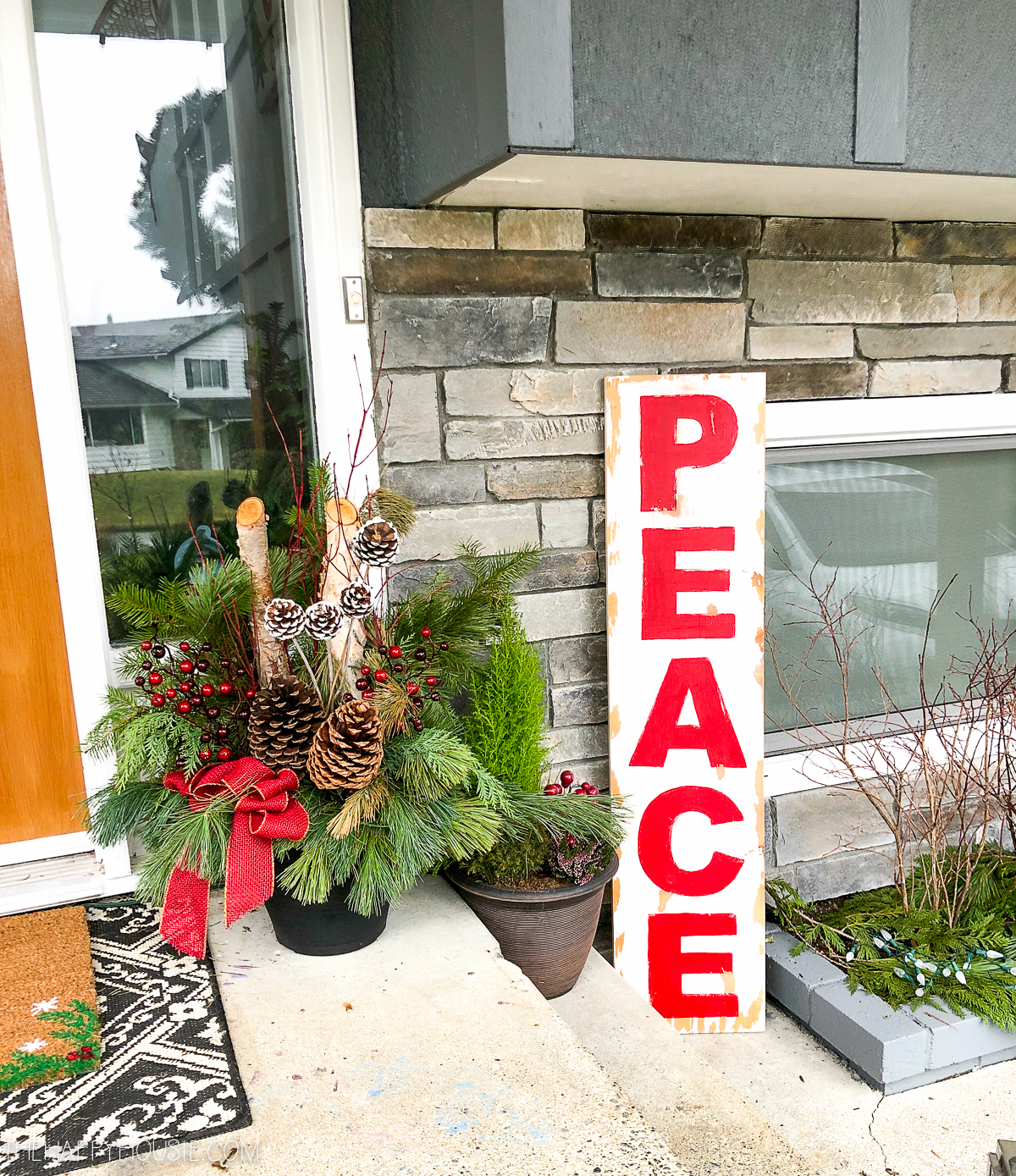 A peace sign next to the planters by the front door.