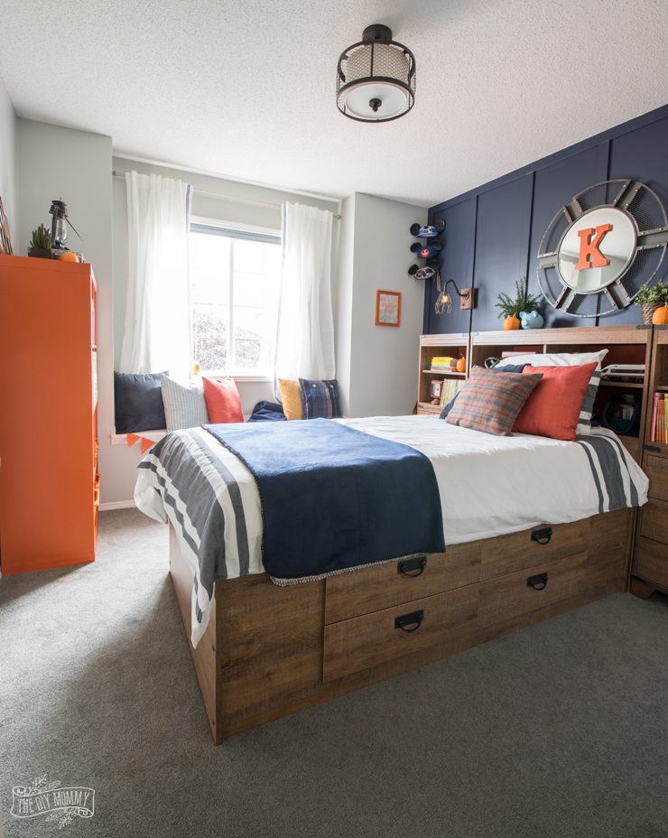 A wooden bed with an orange armoire.