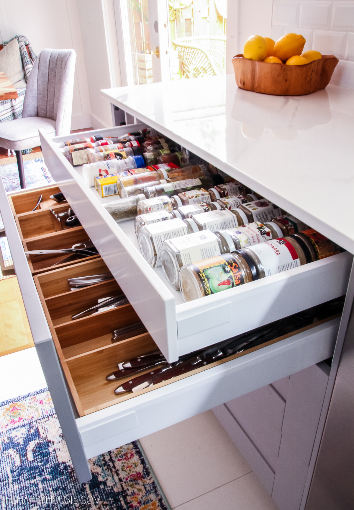 Opened kitchen drawers with spices and cutlery.