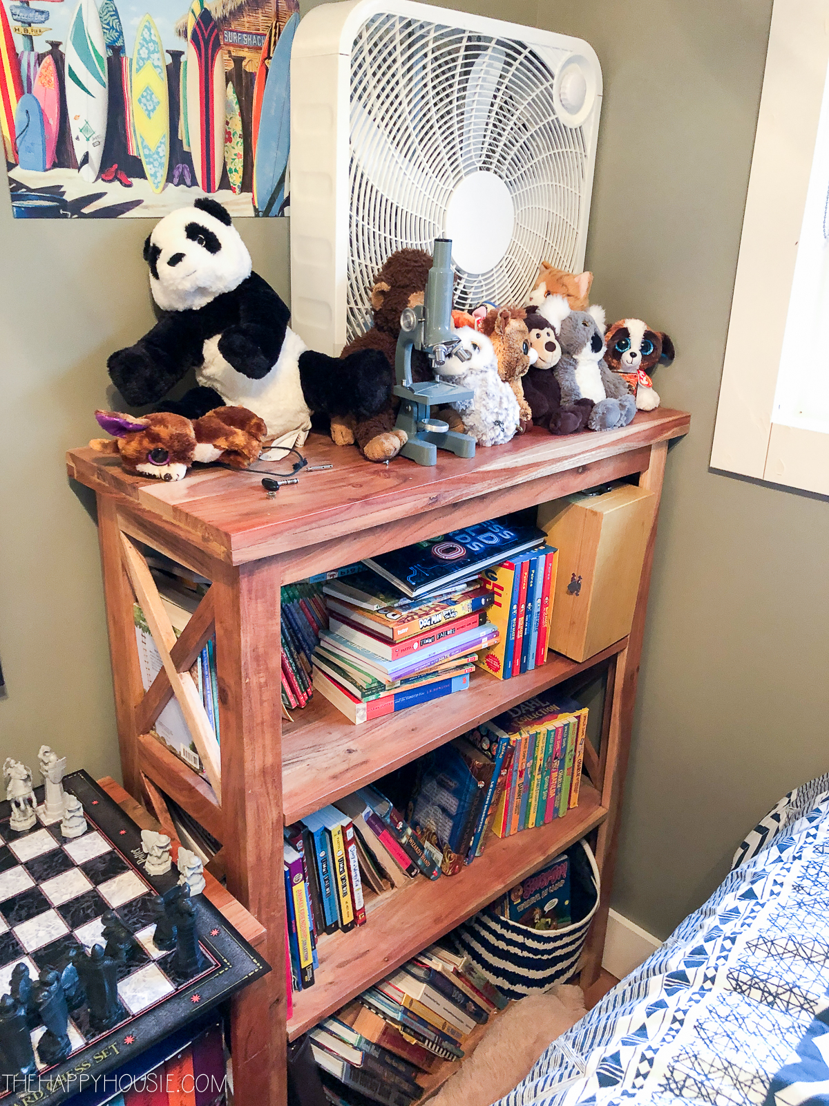 A bookshelf has all the books and stuffed animals.