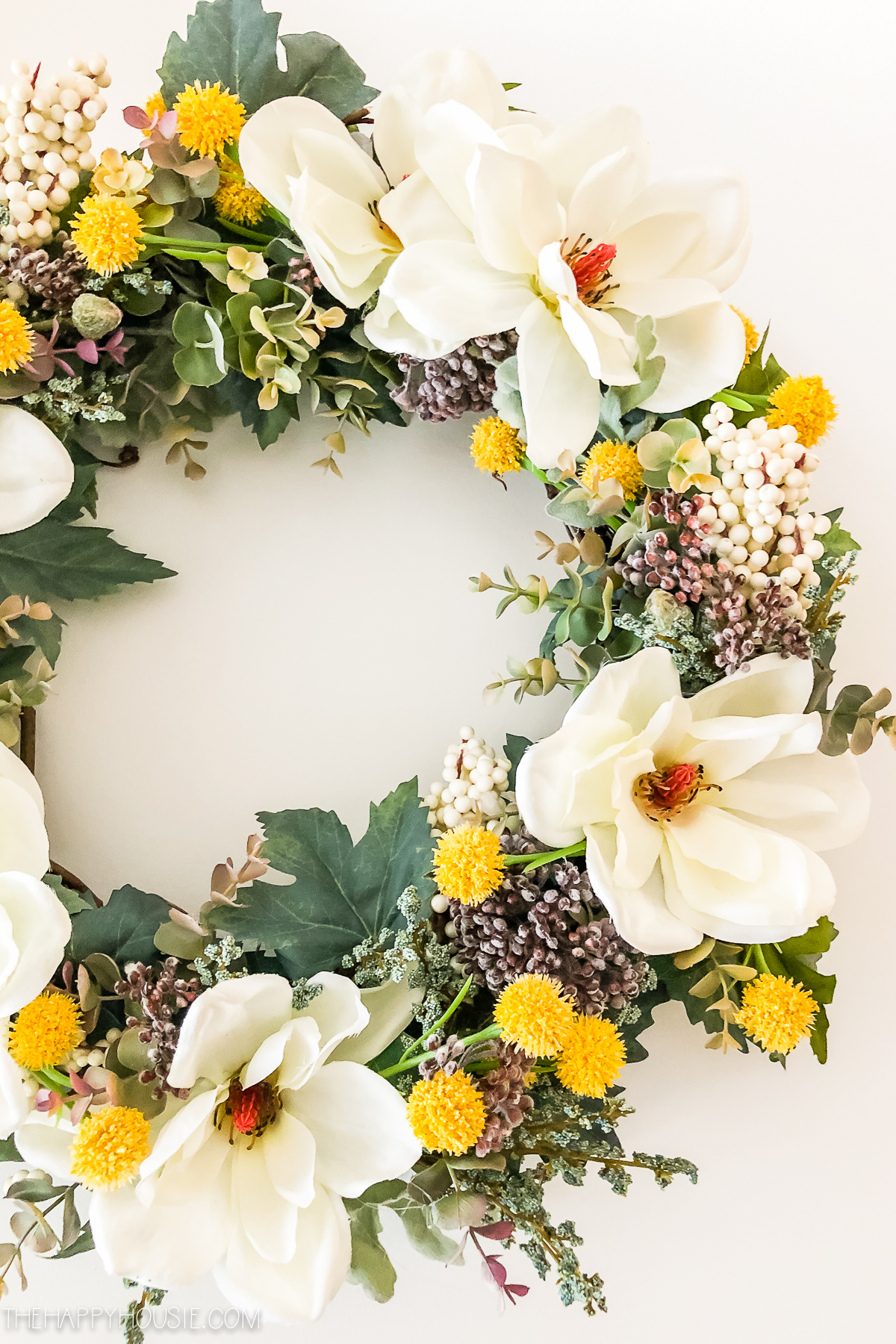 Showing the white flowers with the red centers of the wreath.