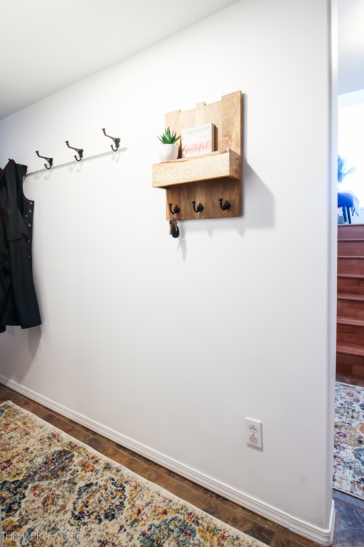 A small wooden key shelf is on the wall.