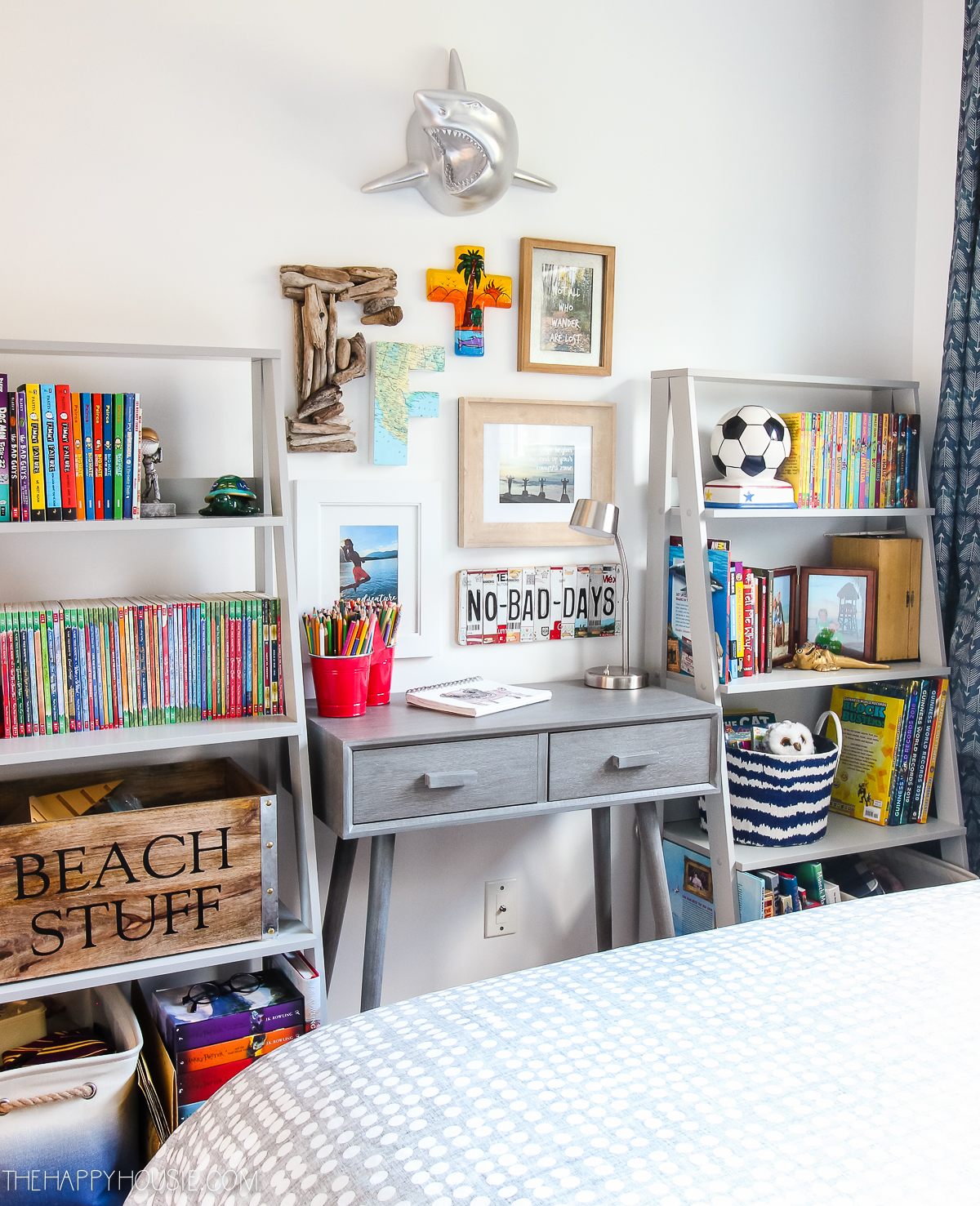 A small desk is in between two bookshelves in the bedroom.