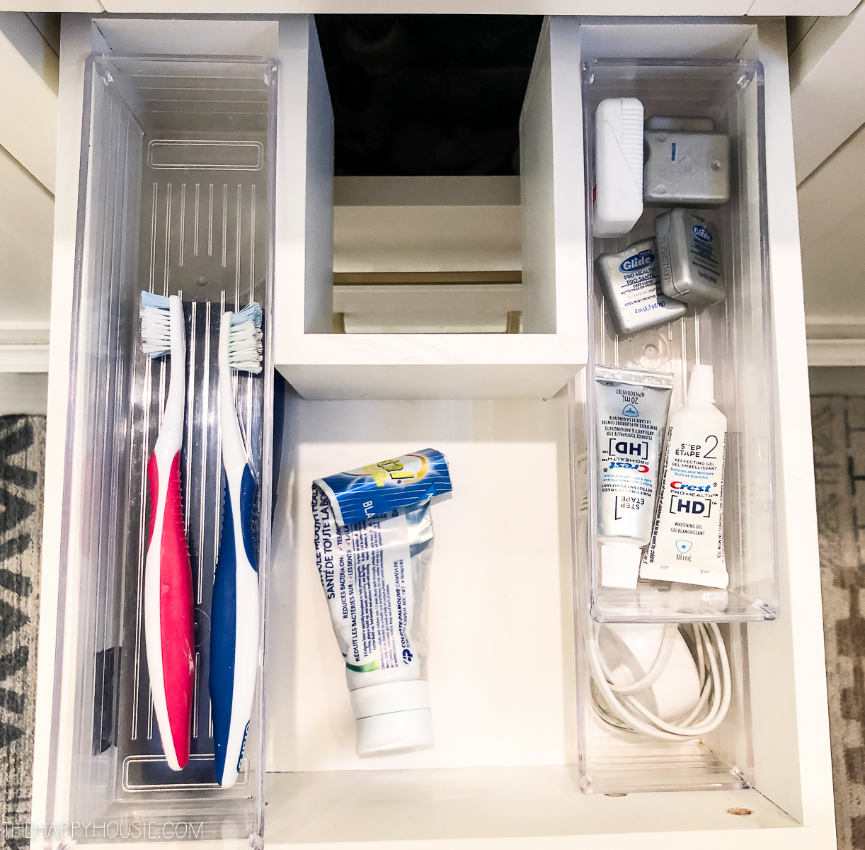Opening the drawer in the bathroom revealing toothbrushes and floss.