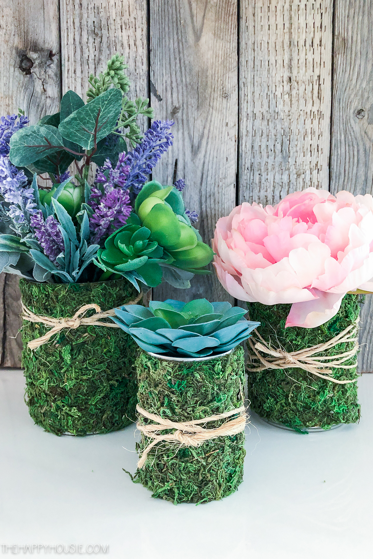 Succulents, and florals in the moss covered cans.