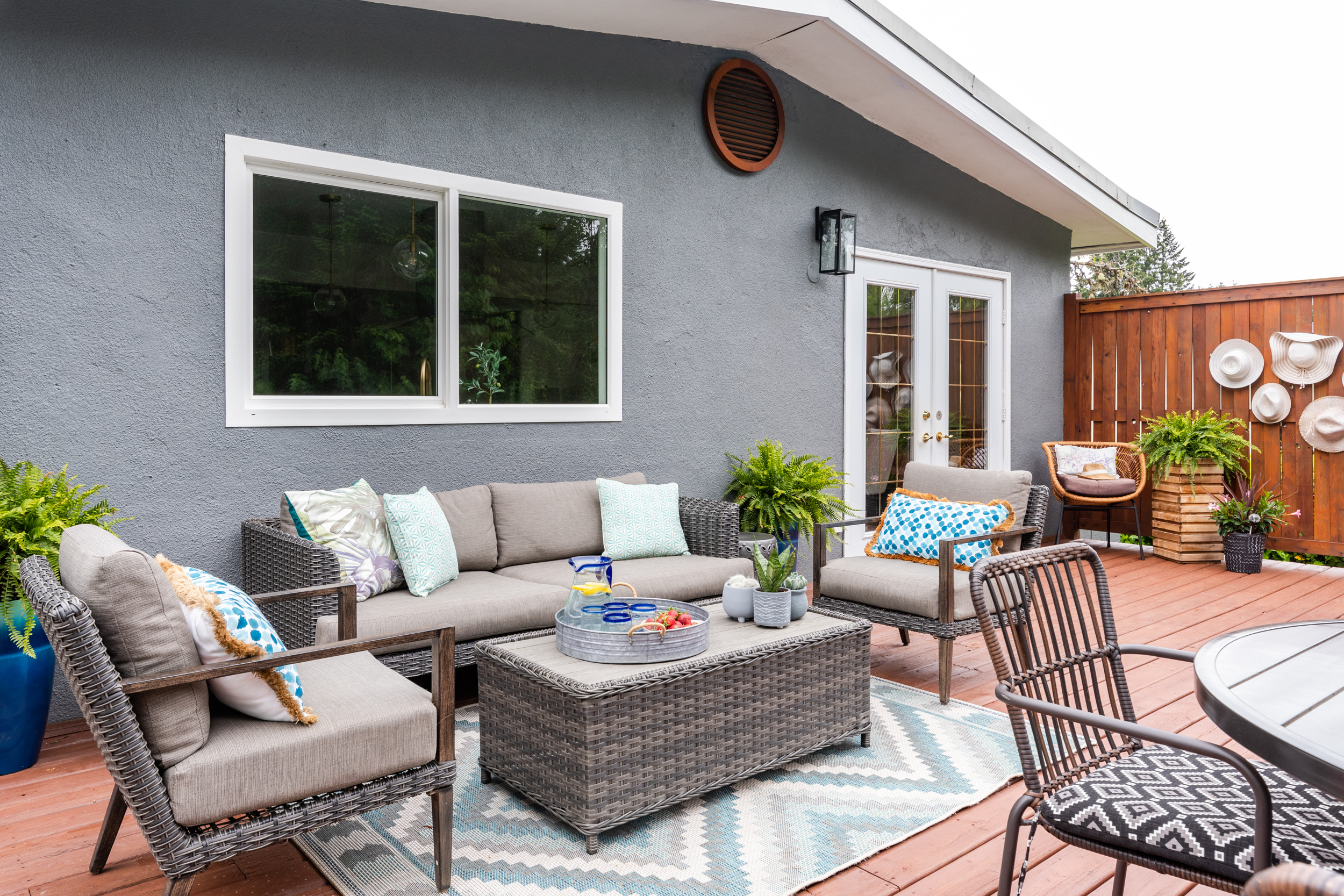 a modern resin outdoor seating set with an outdoor area rug on a freshly stained and painted back deck