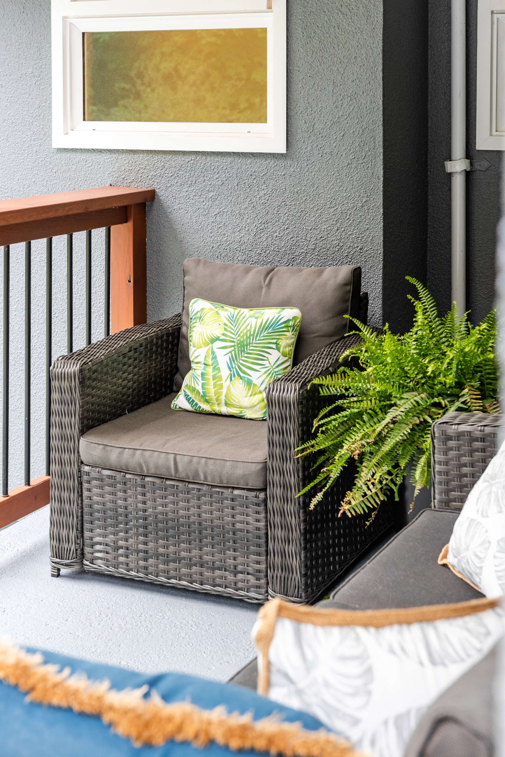 An outdoor armchair with a palm pillow.