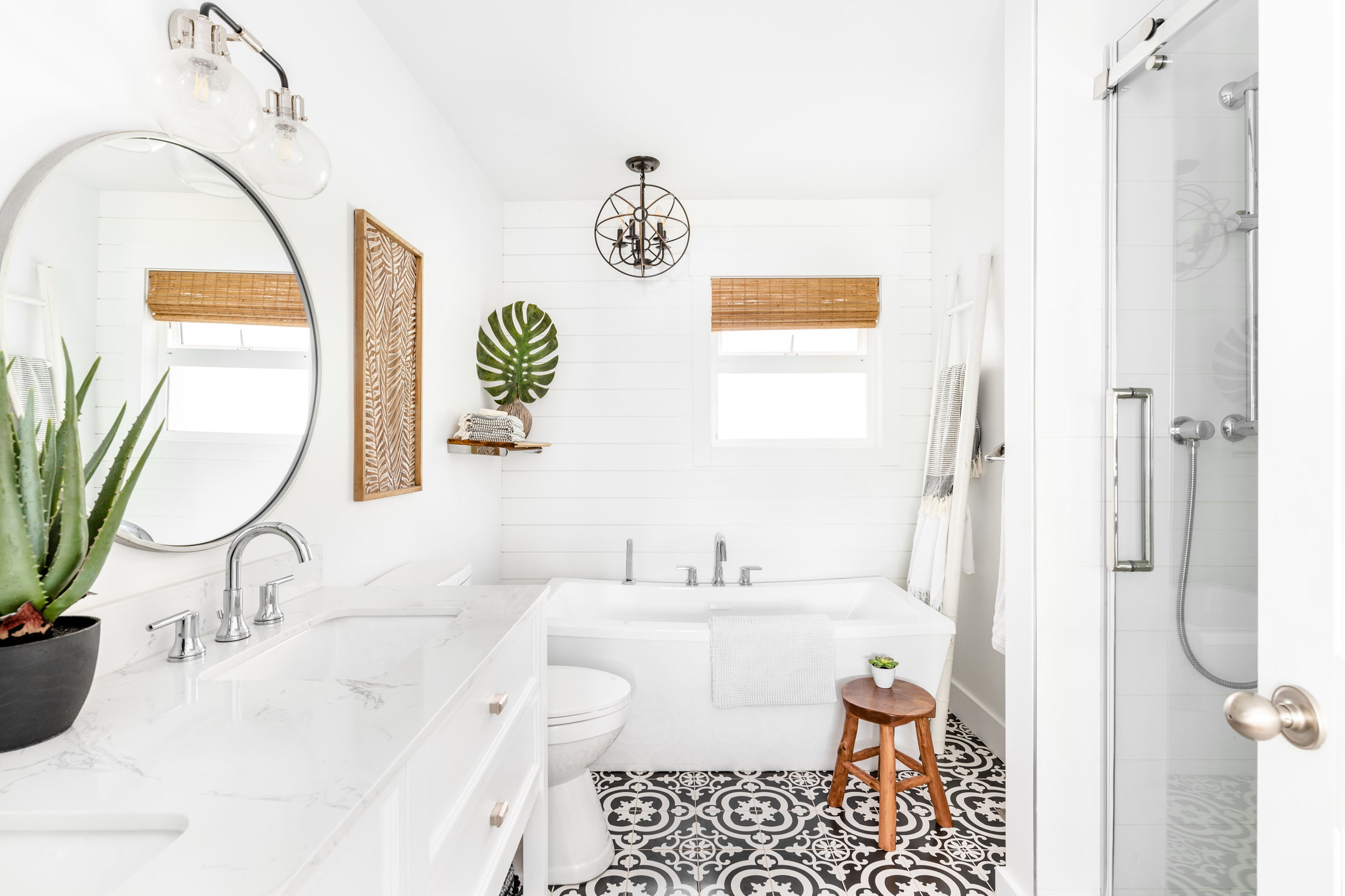 a large bright main bathroom with vintage tile floors and white shiplap feature wall
