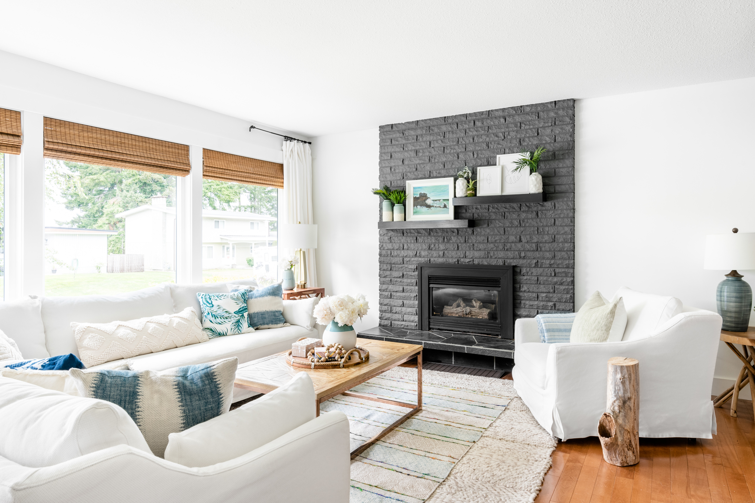 living room decorated with white slipcovered Ikea Farlov sofas and a dark grey brick fireplace