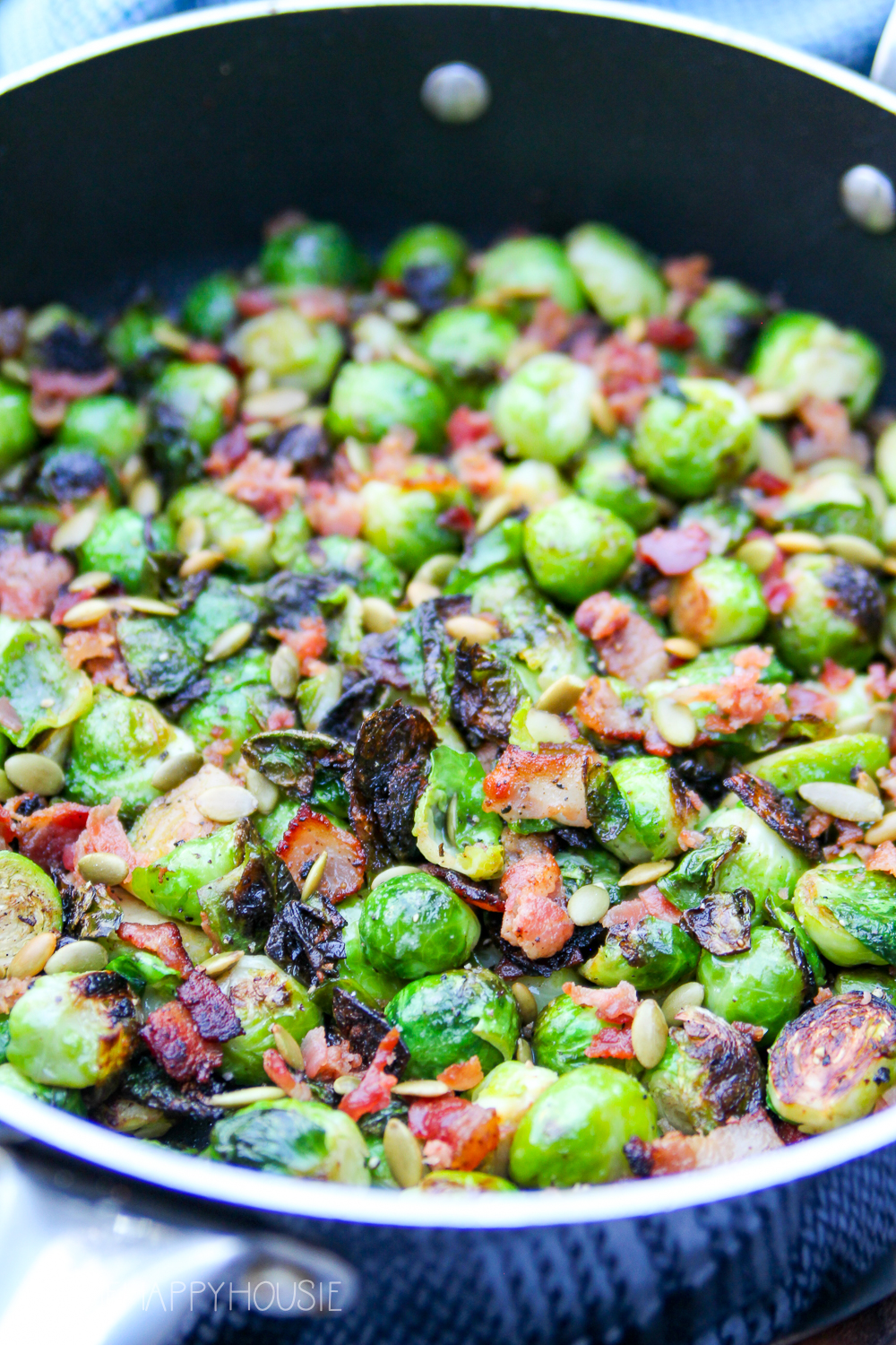 The Brussel sprouts in the frying pan with the bacon.