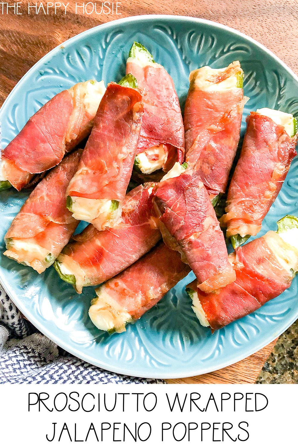 The prosciutto wrapped jalapeno poppers on a blue plate.