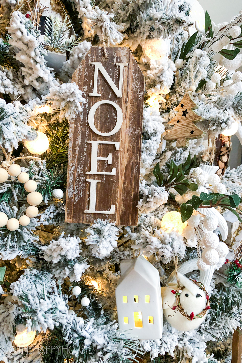 Up close picture of the NOEL wooden sign on the tree.