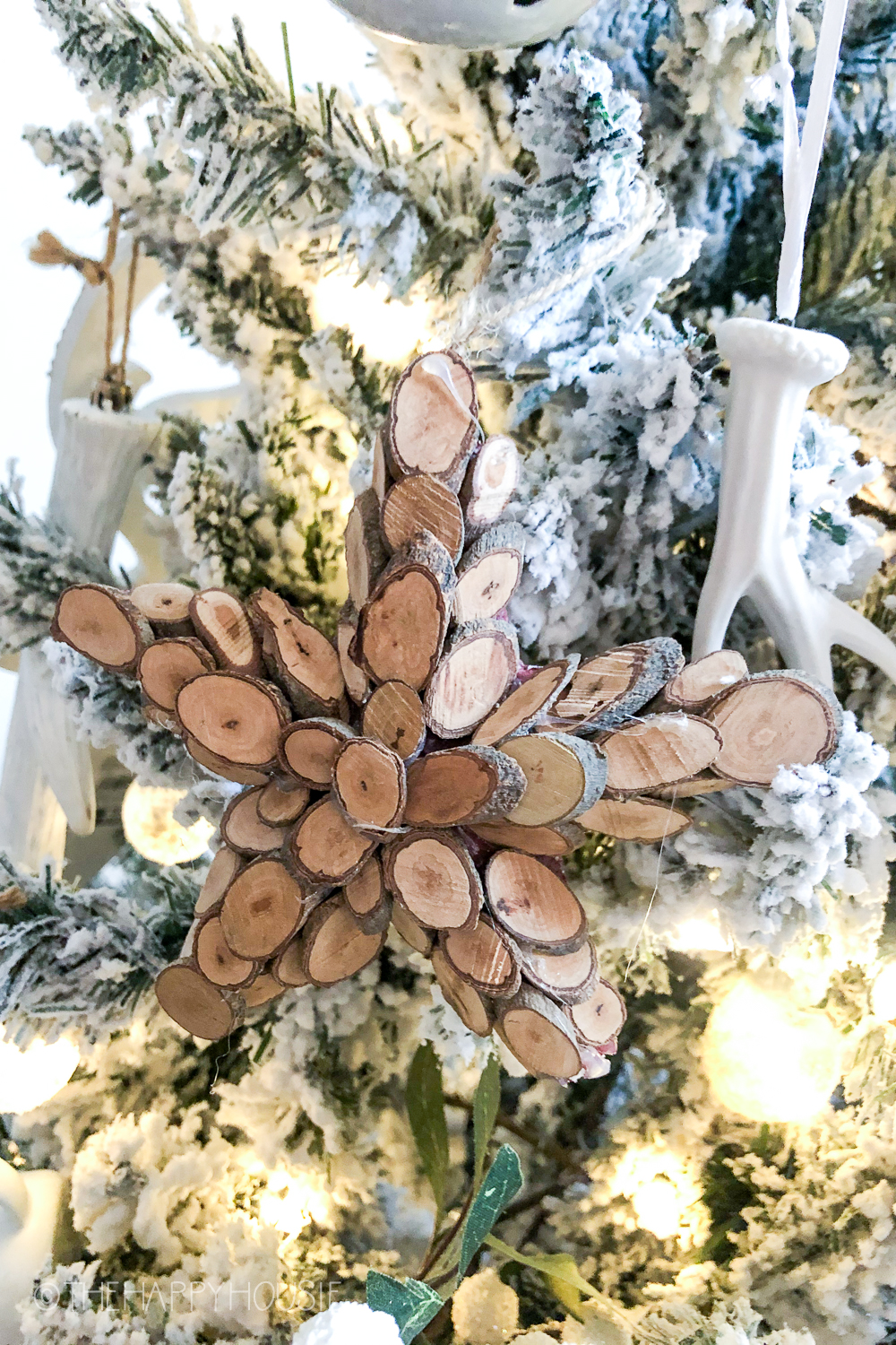 A star made out of wood chips is on the tree.