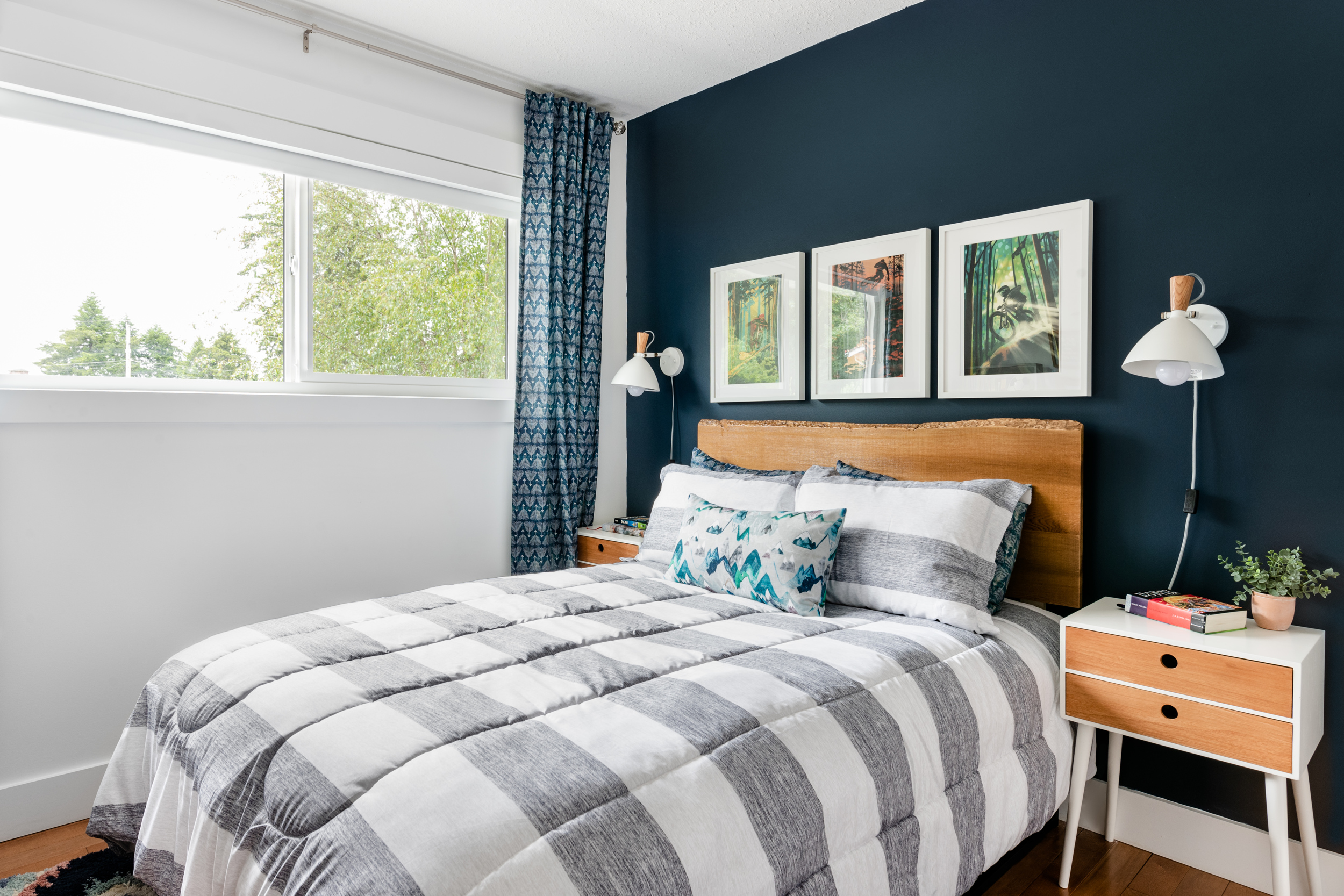 a cute boy's bedroom with a Hale Navy feature wall and live edge headboard double bed
