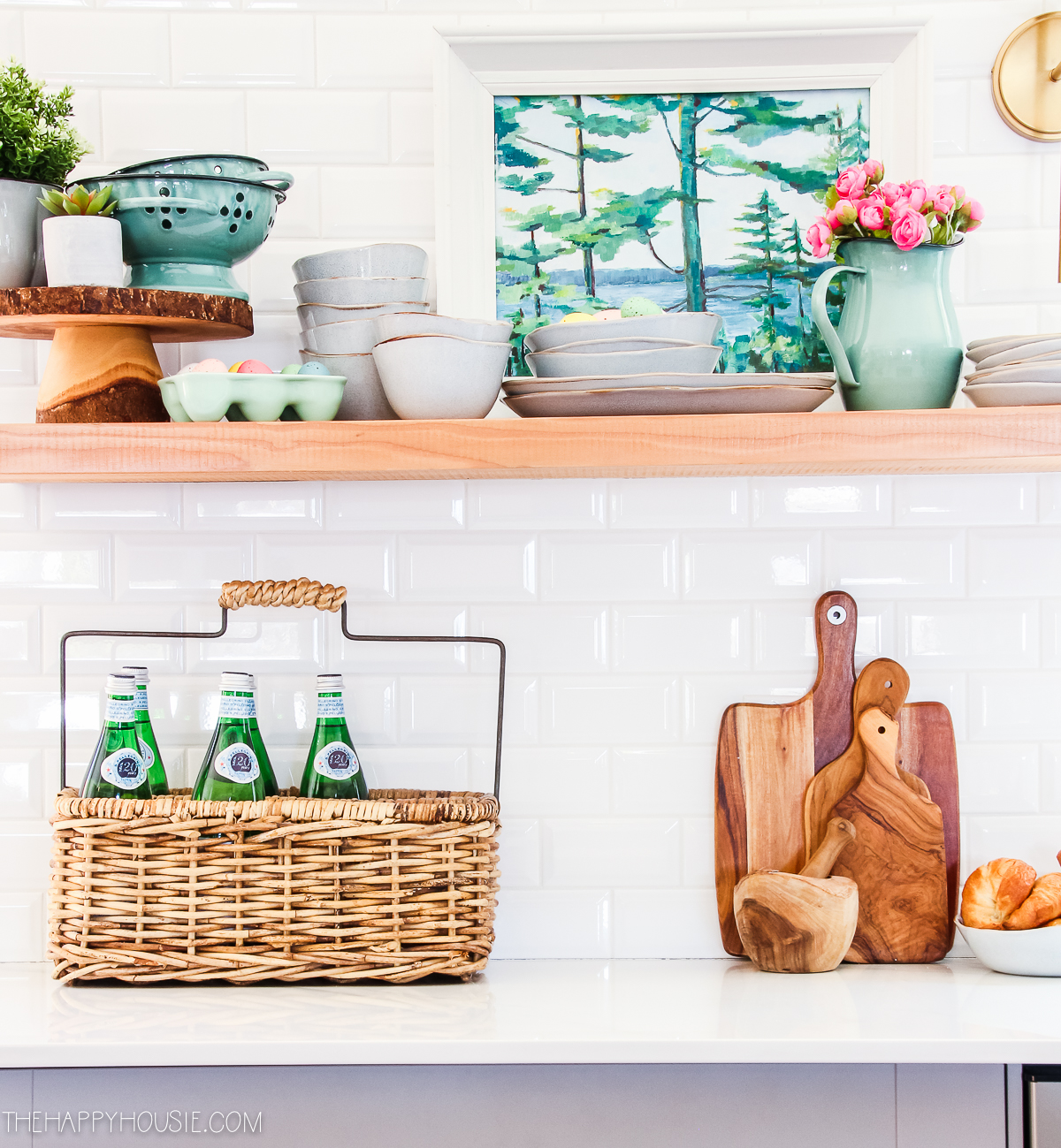 Open shelves in the kitchen with a basket and wooden cutting boards on it.
