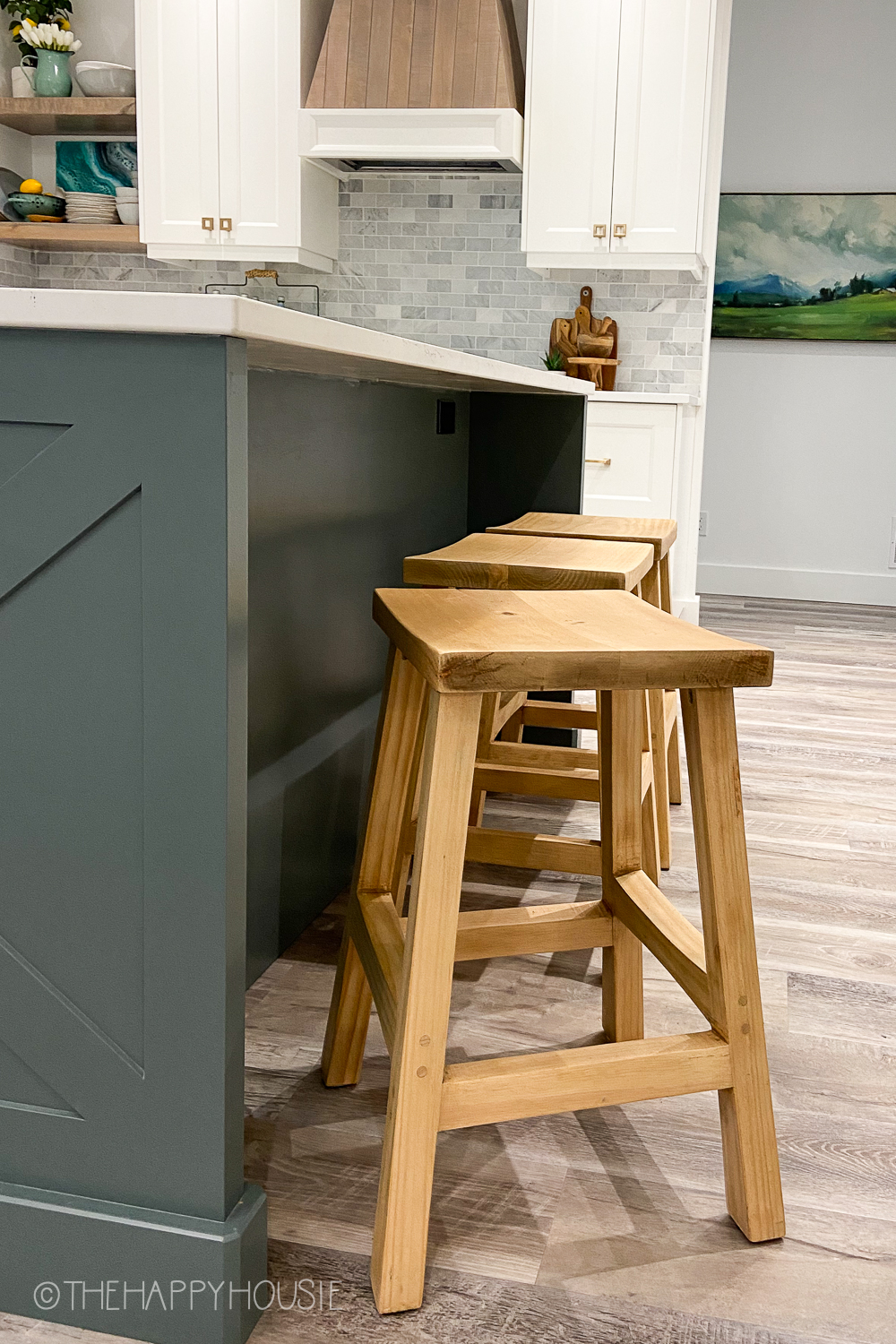The wooden stools at the grey kitchen island.