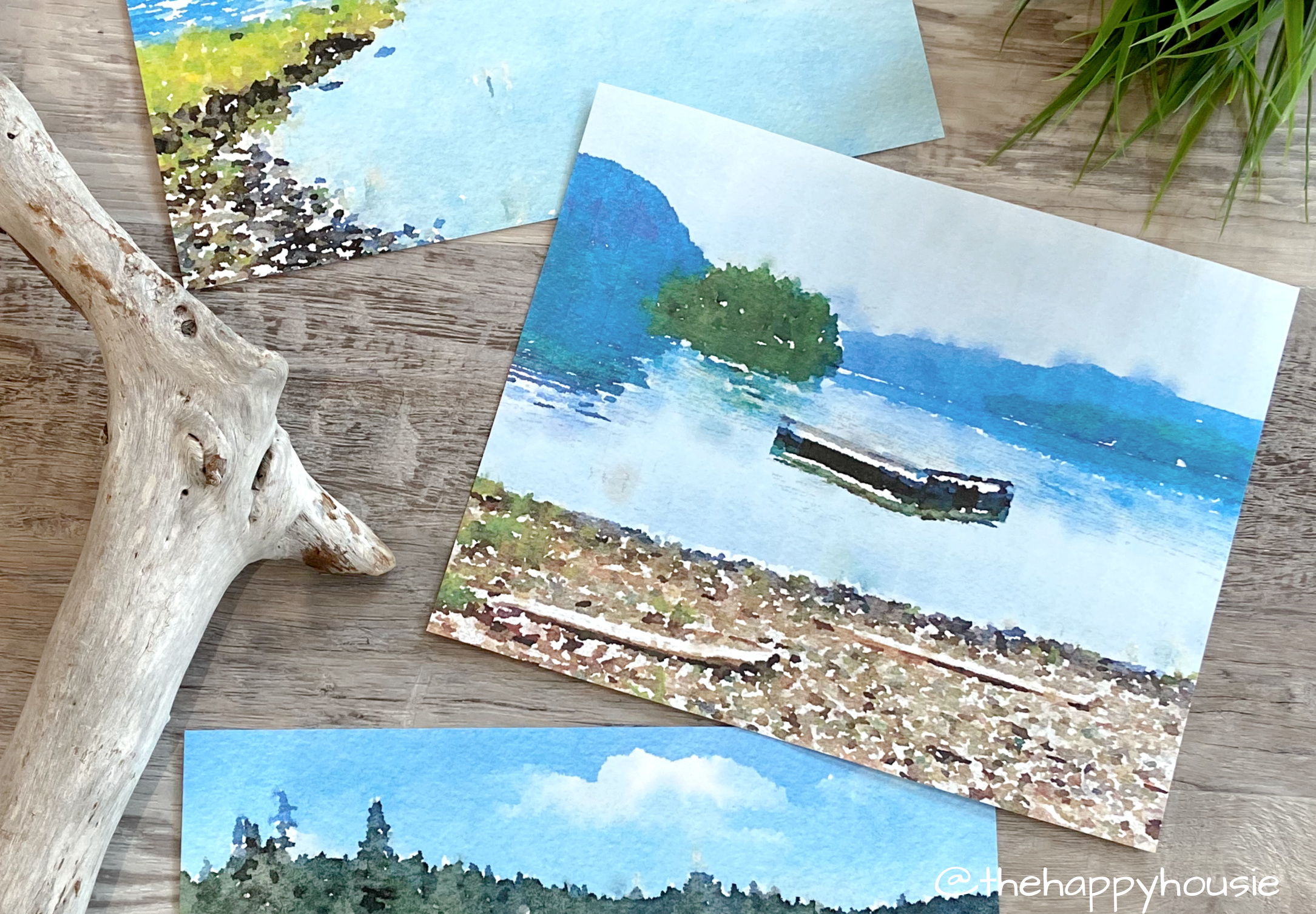The printables on the table beside a piece of driftwood.