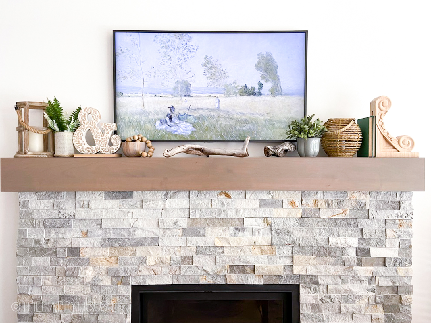 A frame TV on top of a fireplace mantel.