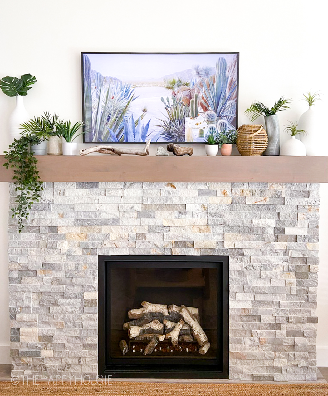 A stone fireplace with a Frame TV on the mantel.