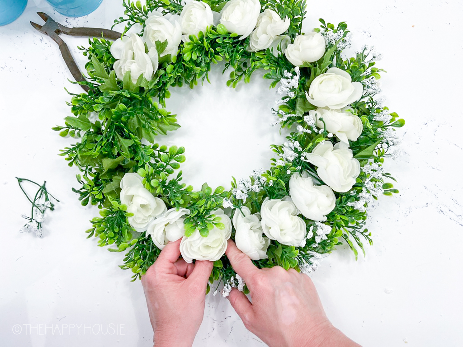 The pretty green wreath with white flowers all around it.