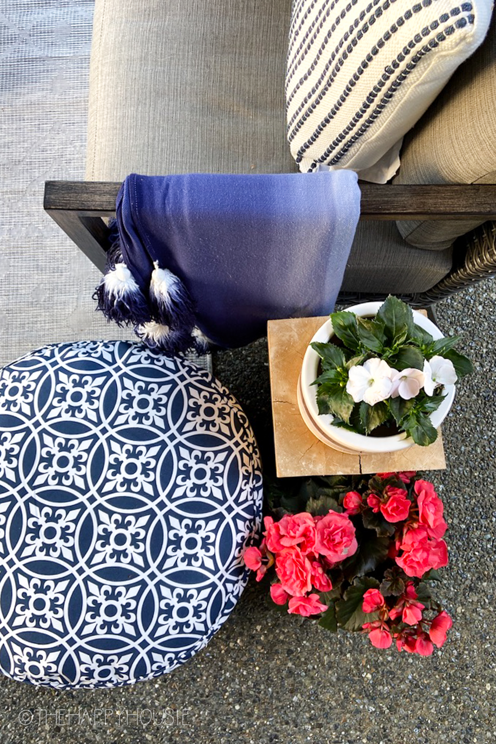 There is a blue and white pouf and a blue and white throw blanket.