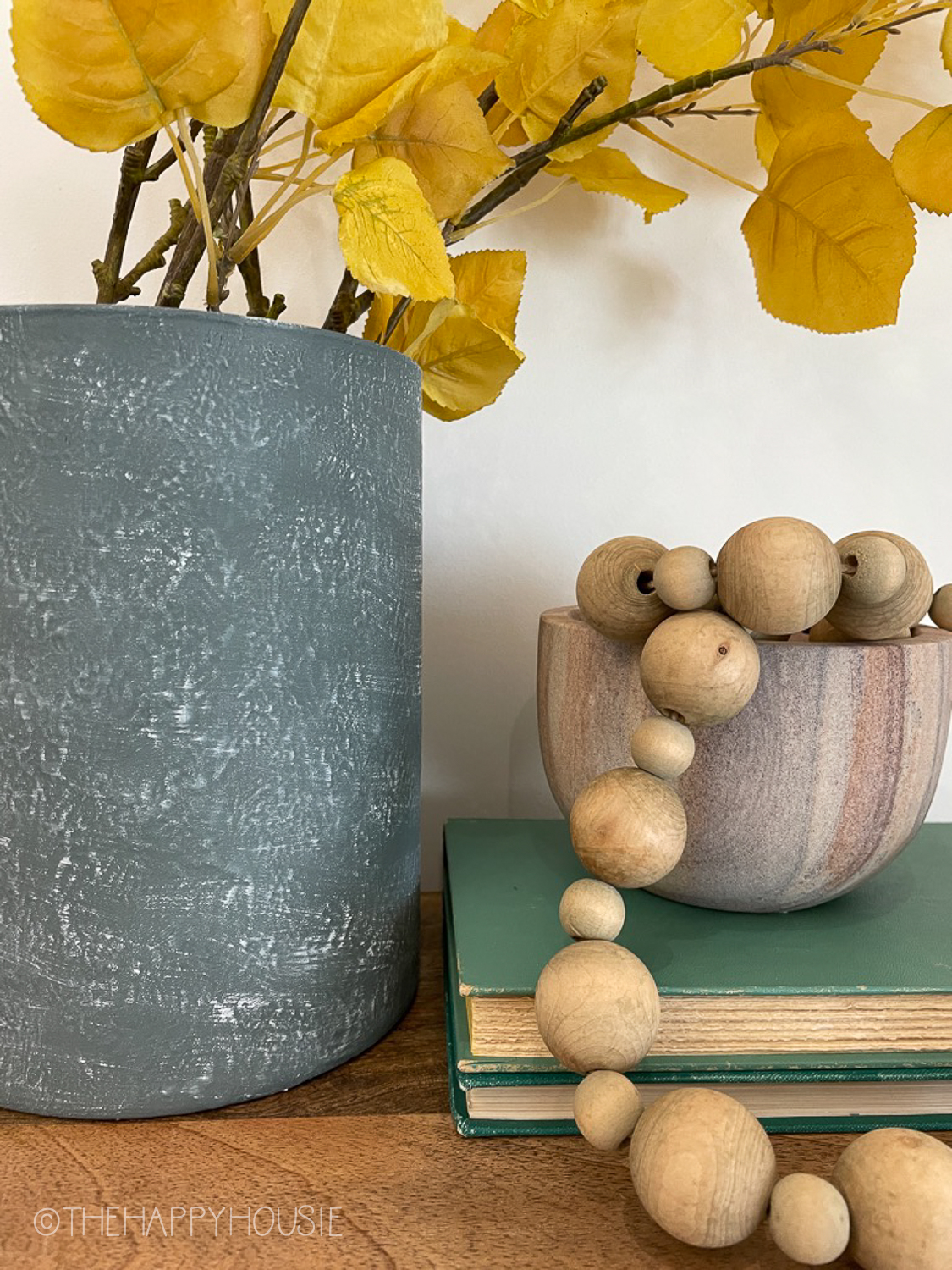 The textured vase beside wooden beads.