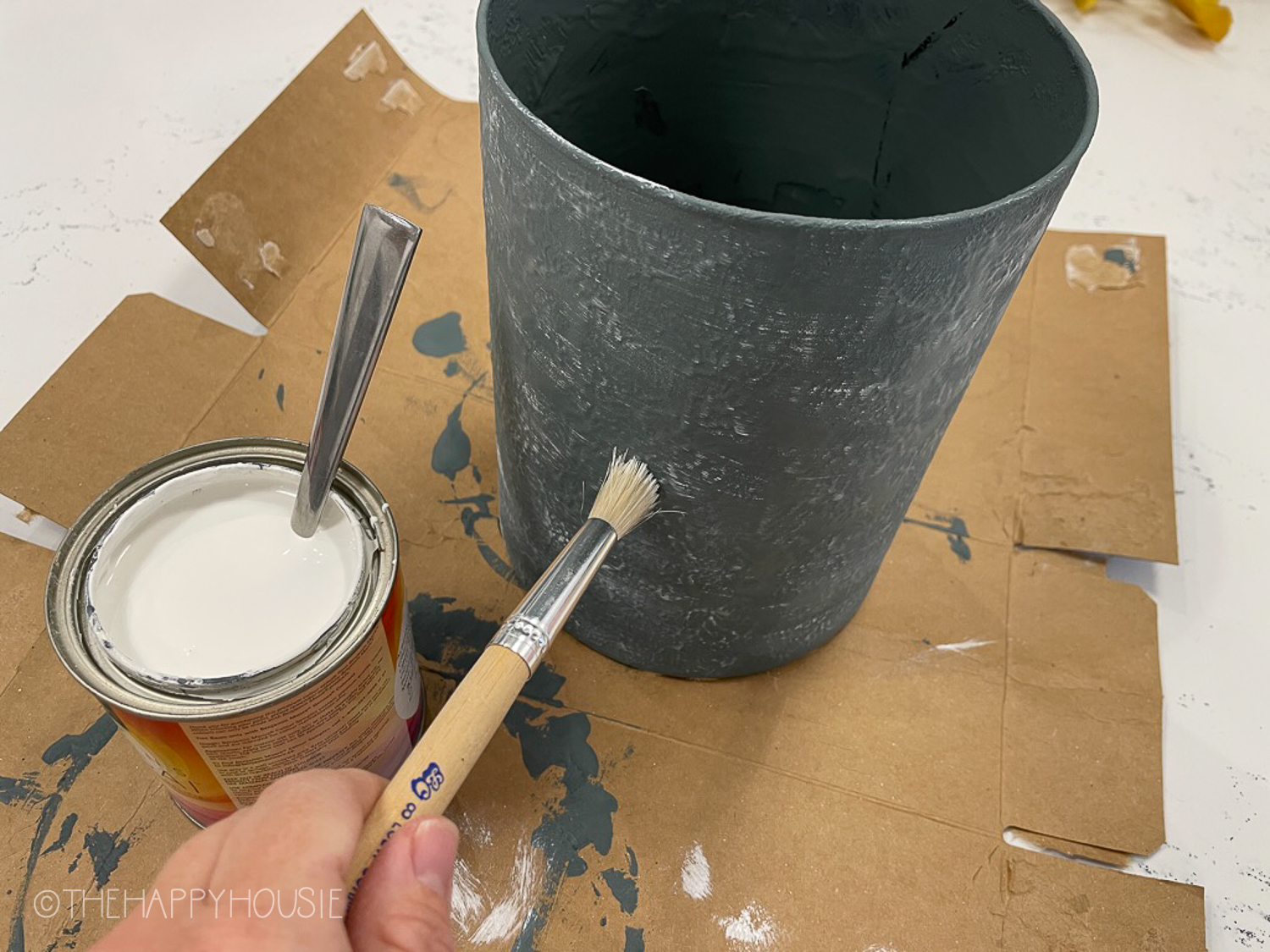 Applying a bit of white paint to the vase.